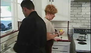 Younger guy gets blown by 70 year old redhead in kitchen